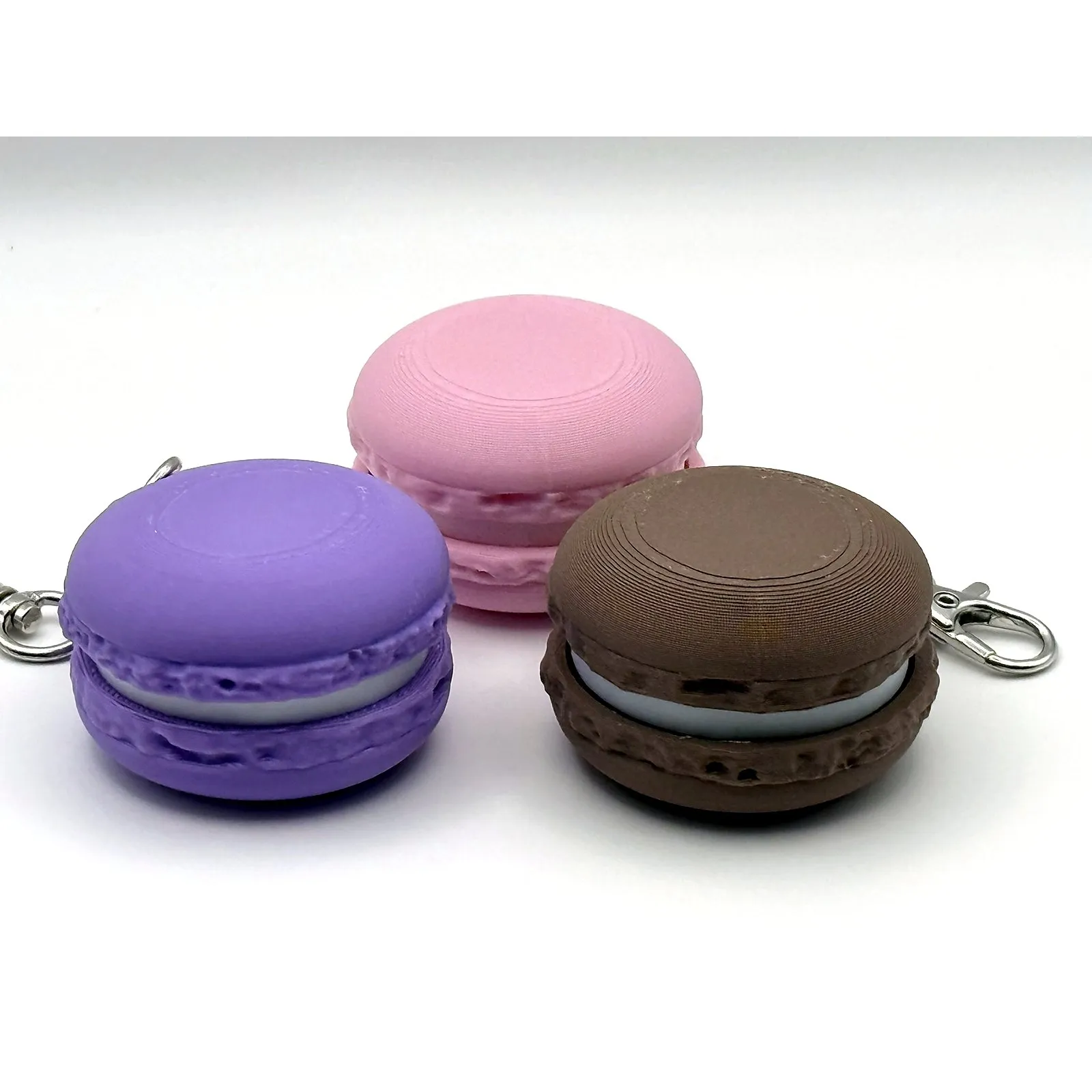 Three pastel macaron-shaped 3D printed clickers arranged on a white surface.